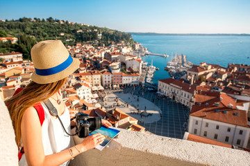 A traveller with a camera looking out over Piran's old town and the sea from the town walls